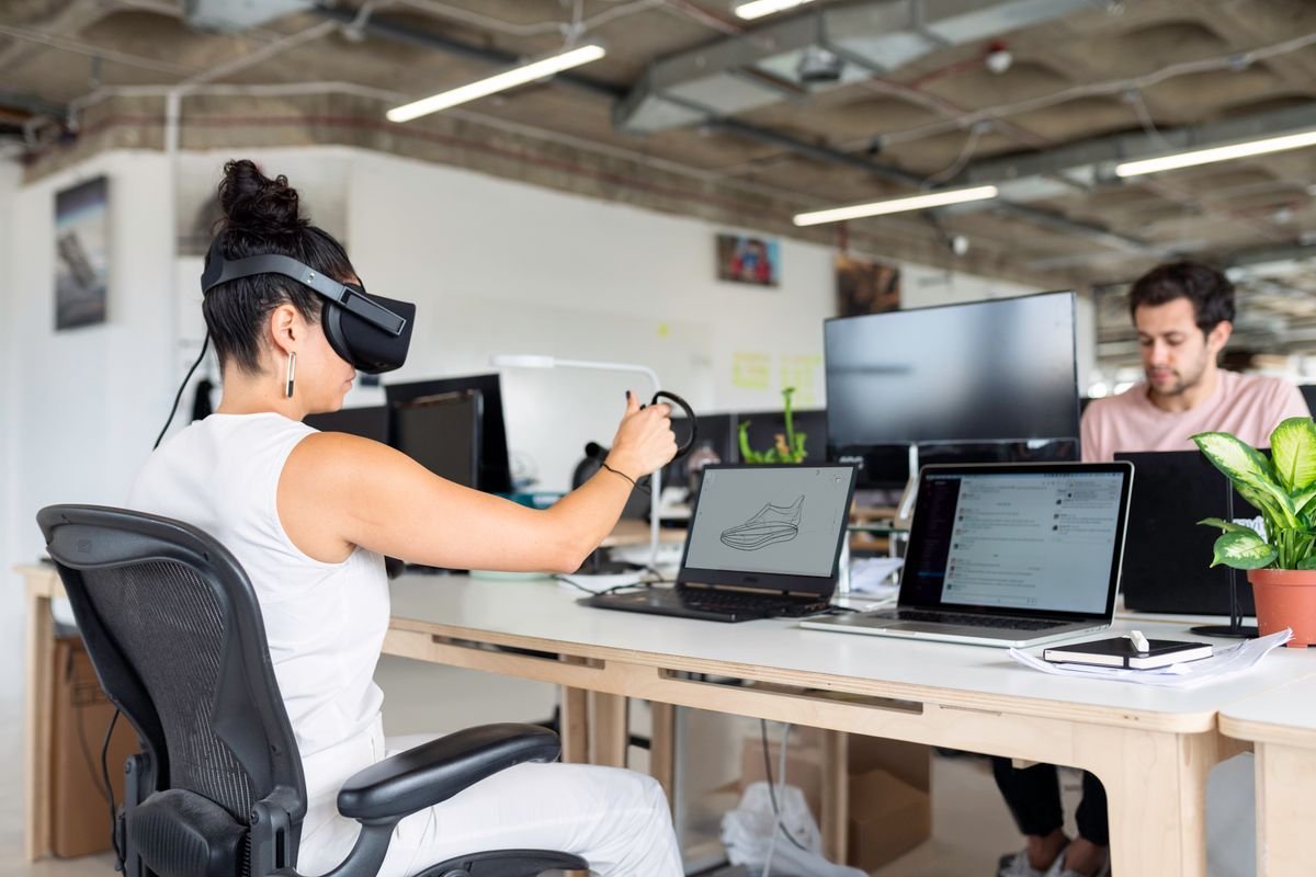 Engineer using a VR headset at a design workstation in a modern engineering office