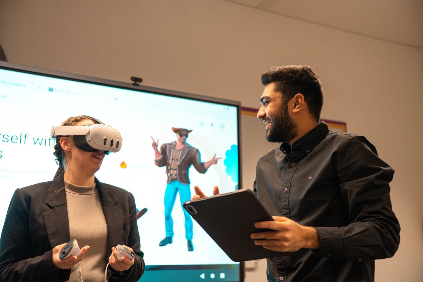 Professionals collaborating with a VR headset, tablet and large 3D display in a modern office