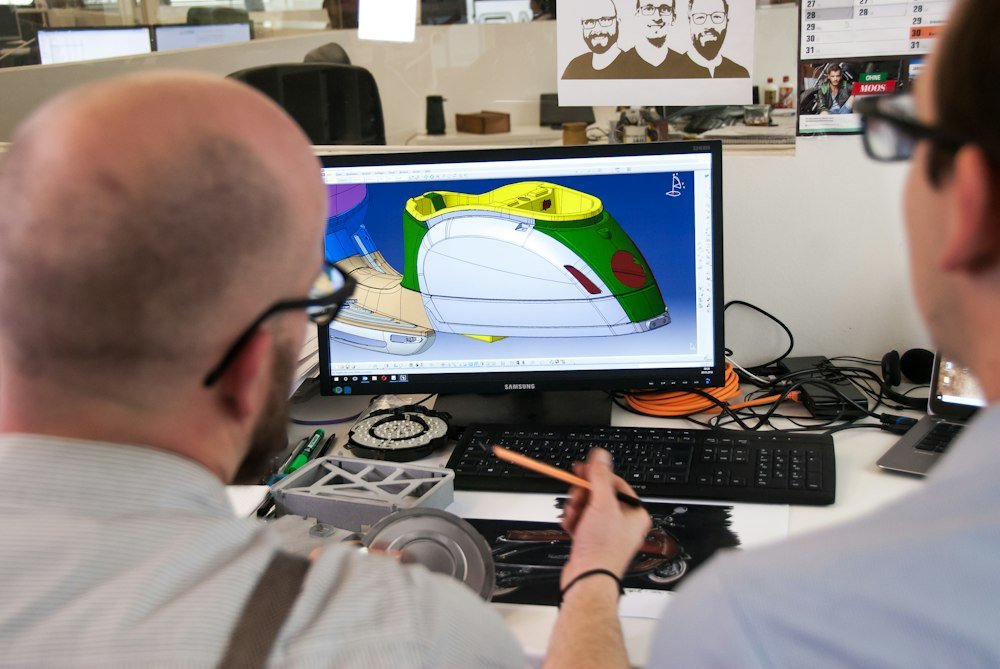 Engineers reviewing a 3D product model on screen for digital prototyping