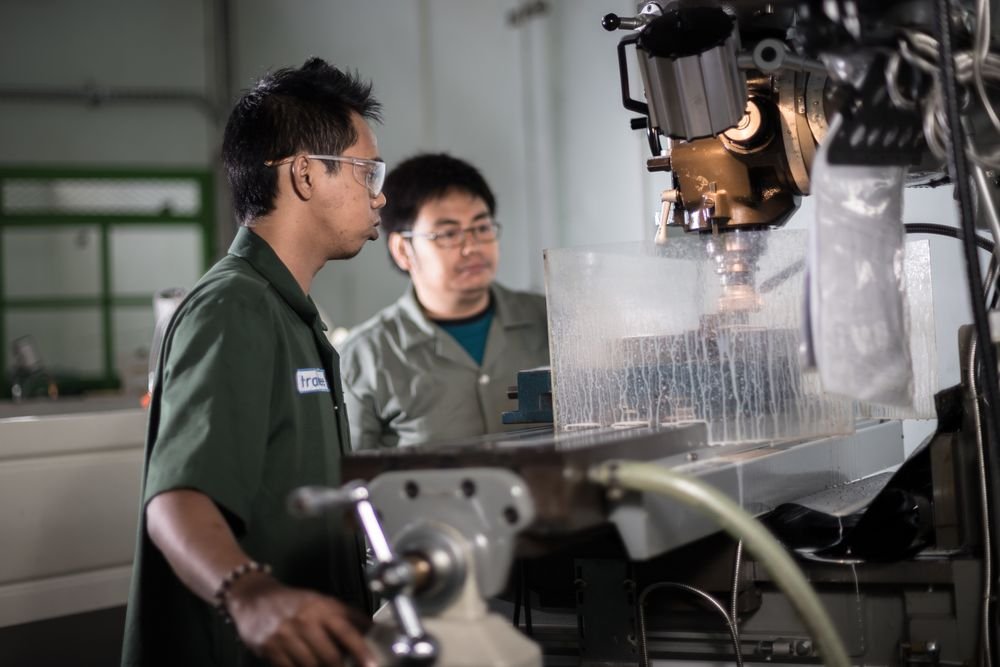 Technicians working together at a CNC machine during guided maintenance